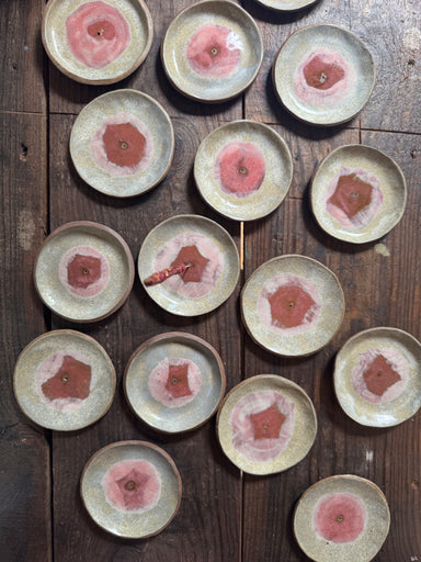 Set of ceramic plates with pink floral designs on a wooden surface