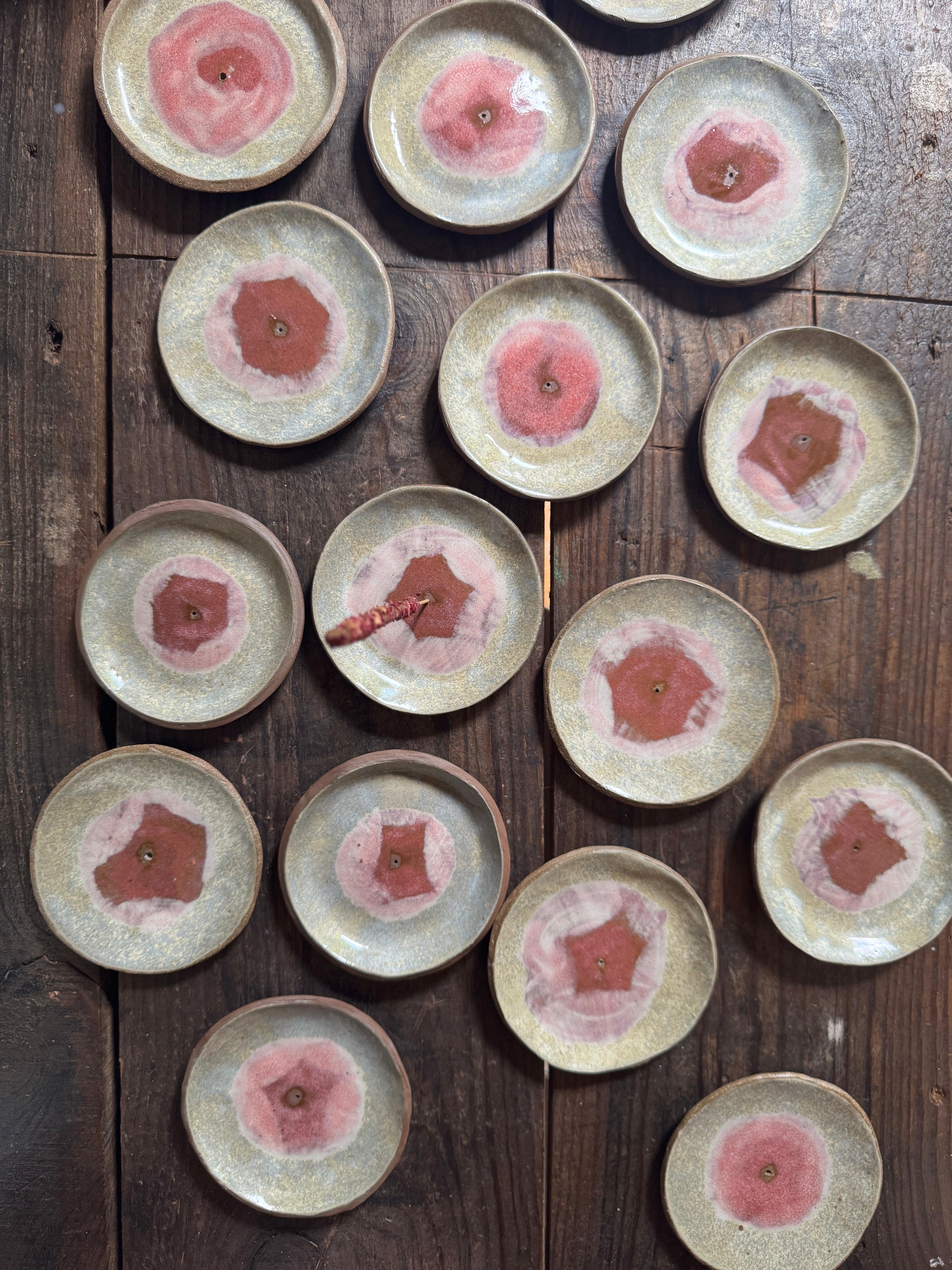 Set of ceramic plates with pink floral designs on a wooden surface