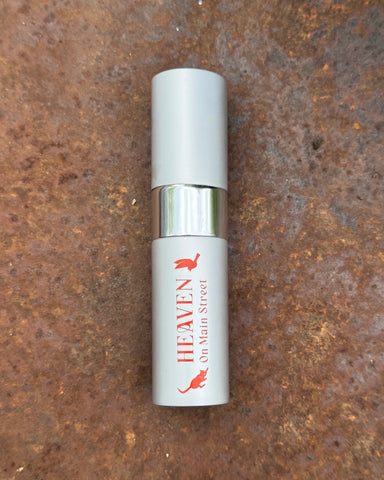 Small cylindrical container with 'Heaven on Main Street' branding on a rusty metal surface